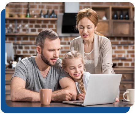 Young couple and cute child girl using laptop in kitchen